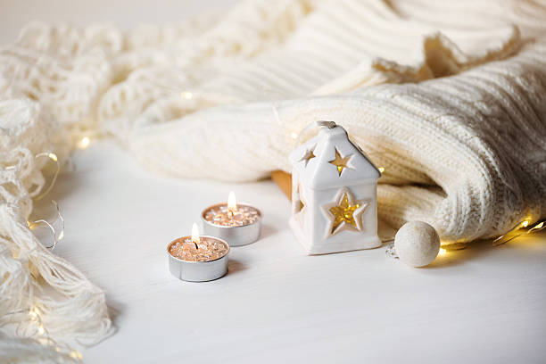 istock Cozy winter. Knitted plaid, candlelight and candlestick on festive lights background 2241407813