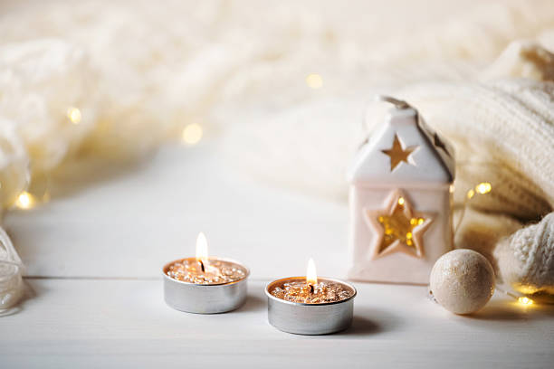 istock Cozy winter. Knitted plaid, candlelight and candlestick on festive lights background 2241407823
