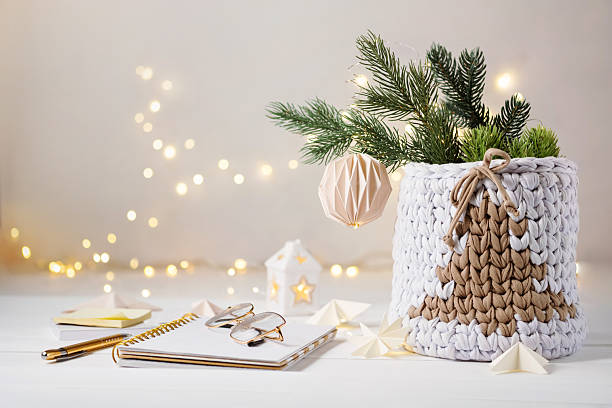 istock Notepad, pen, glasses, stationery for writing down a plan or a wish list. Cozy Christmas decoration. Knitted basket with Christmas tree on festive lights background 2241407889
