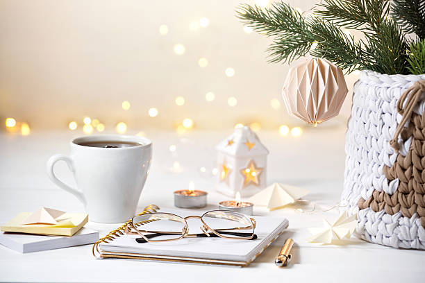 istock Notepad, pen, glasses, stationery for writing down a plan or a wish list. Cozy Christmas decoration. Knitted basket with Christmas tree on festive lights background 2241407904