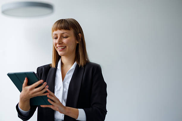 istock Young businesswoman smiling while working on a digital tablet, managing business with modern technology in a bright office 2241408000