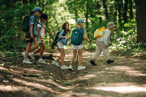 istock Side view, going together. Group of children in the forest on a hike 2241408763