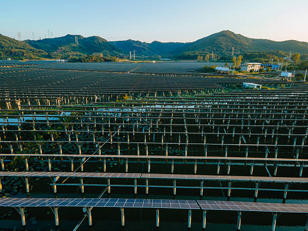 istock Floating solar panels on calm lake water under clear sky, renewable energy installation, sustainable green technology with reflective water surface, eco friendly power generation and modern clean energy solutions. 2241411095