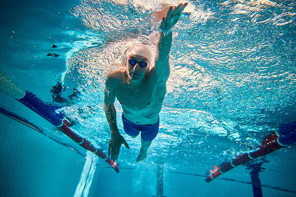 istock Competitive swimmer gliding underwater in freestyle with determination 2241412996