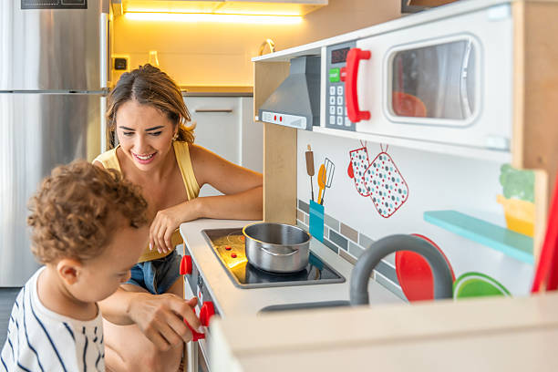 Happy parents and their sons having fun during morning time in the kitchen.