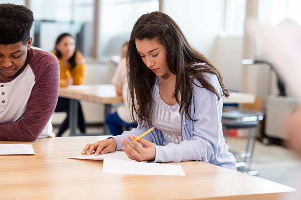 istock Teenage students focusing intensely on their tests in a classroom setting. 2241419677