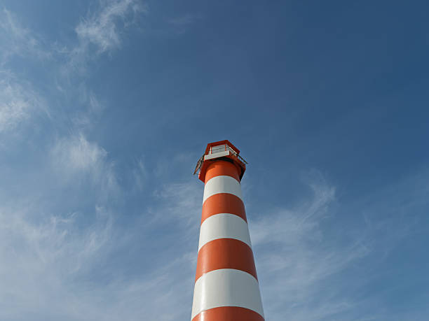Traditional coastal lighthouse against a clear blue sky with cirrus clouds - Adicora