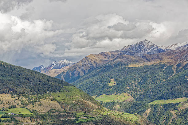istock Dramatic mountain landscape with wild clouds above high, snowcapped mountain ranges 2241427960