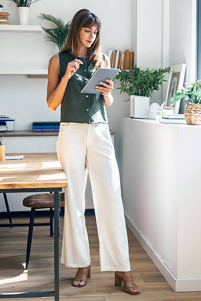 istock Beauty business woman using her digital tablet while working in a modern startup office. 2241428010