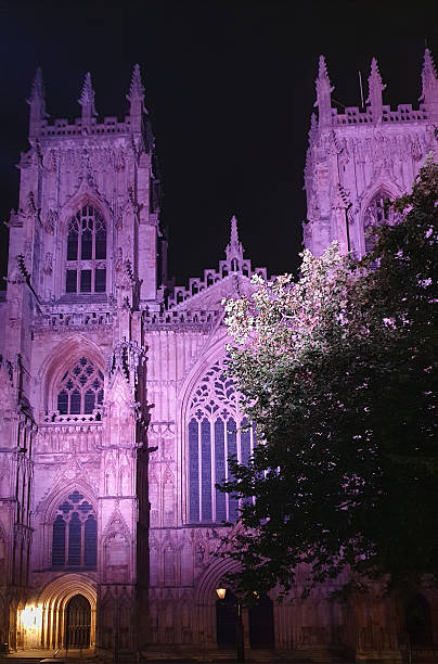 West front exterior, with its two towers of York Minster, a medieval (1230-1472) Gothic Cathedral in the city centre, lit up at night. England.