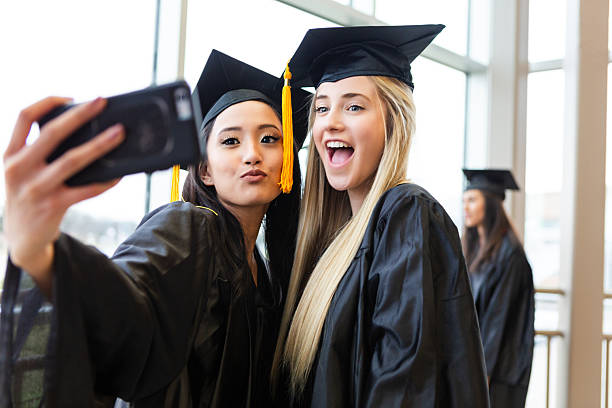 istock Graduating students in caps and gowns taking a selfie together and celebrating. 2241429150