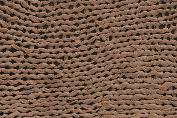 Macro, close up, detailed brown knitted textile, fabric texture with chunky yarn pattern suface. Cozy handmade cloth background, knitwear backdrop , perfect for design, crafts, warm winter concept