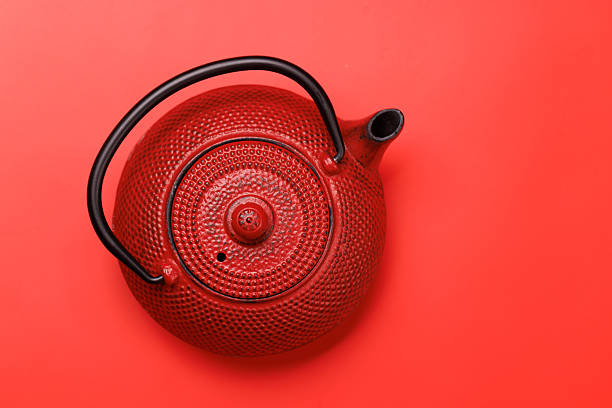 Red teapot on a red background, top view minimal composition