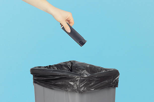 istock throw the lighter in the trash, outstretched hand with a lighter in front of the trash can, the concept of the dangers of smoking cigarettes, quitting smoking 2241432836