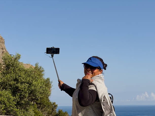 istock Brunette woman laughing while taking a selfie on a sunny day 2241432891