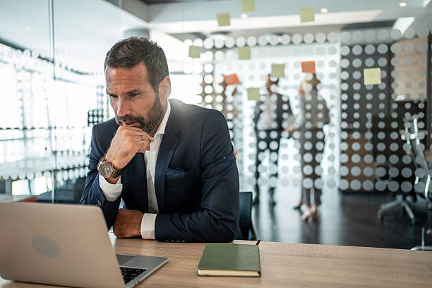 istock Businessman concentrating on laptop, thinking about strategy in office 2241433019