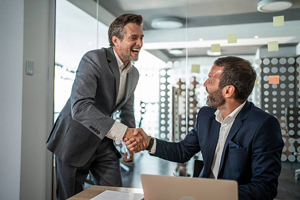 istock Businessmen shaking hands in office after successful deal 2241433082