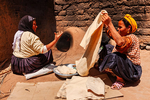 istock Moroccan women baking bread - khubz 2241435438