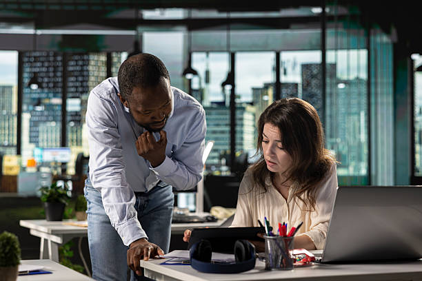 istock Coworkers consulting on project reports and performance in workspace 2241437559