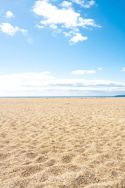 Dartmouth beach meets the blue ocean under a cloudy sky in devon, england