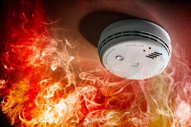 Smoke detector and fire alarm in action background with copy space