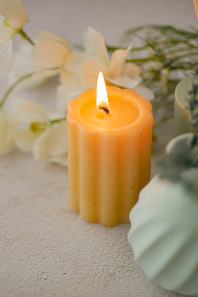 istock Decorative candle with flame and flowers on light surface 2241442834