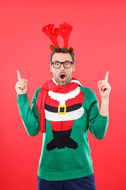 Xmas costume. A man in swhites sweater and with reindeer antlers