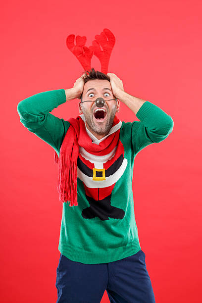 istock Terrified man in funny winter outfit against red background 2241443524