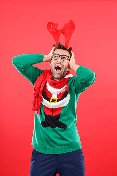 istock Terrified nerd man in funny winter outfit against red background 2241443904