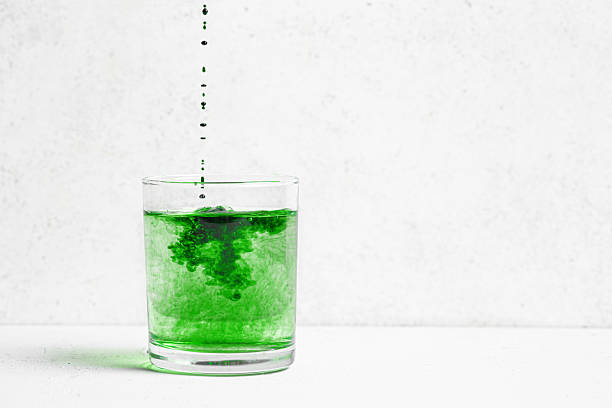Liquid Chlorophyll Drink. Glass of Chrorophyll Water on white background, copy space, template. Healthy eating, clean lifestyle, detox supplement concept.