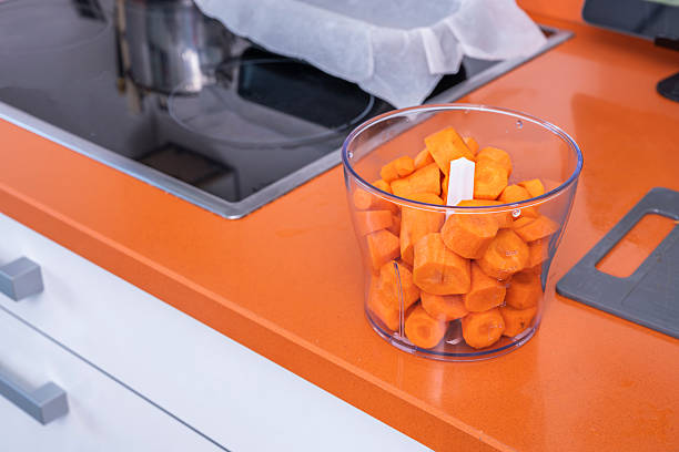 Cut carrots inside a plastic container of an electric chopping machine