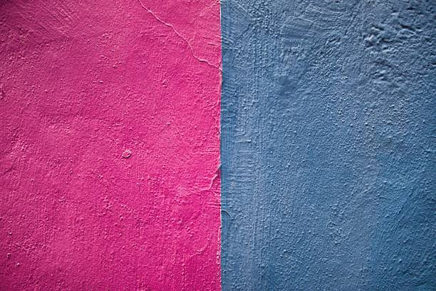 Abstract textured surfaces in contrasting bright pink and cool blue hues create a striking visual composition.