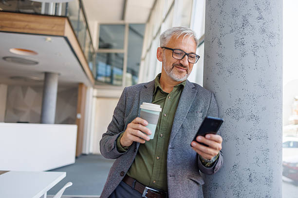 istock Mature businessman enjoying coffee break checking phone 2241450939