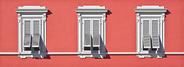 istock Old Neoclassical Italian Facade With Window And Wooden Shutter Against A Red Colored Plaster Wall 2241451766