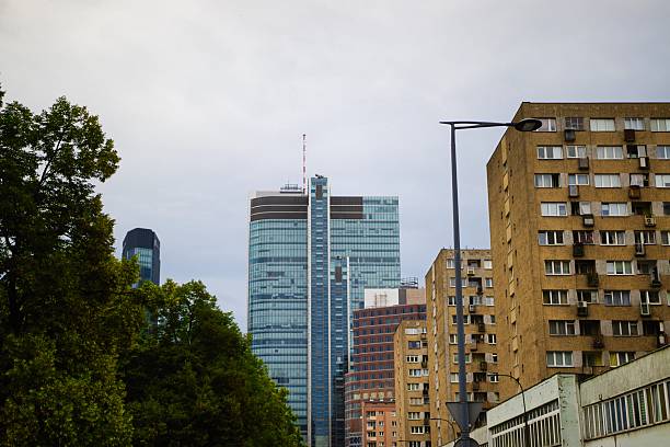 Towering skyscrapers and residential buildings stand tall in a bustling urban landscape, framed by lush greenery in the foreground.