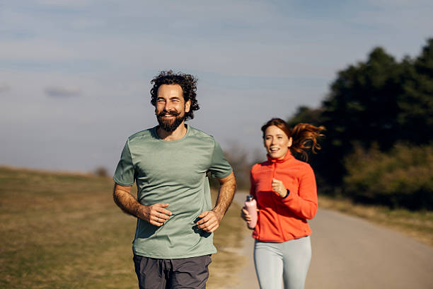 istock Couple running and exercising on path in park 2241458713