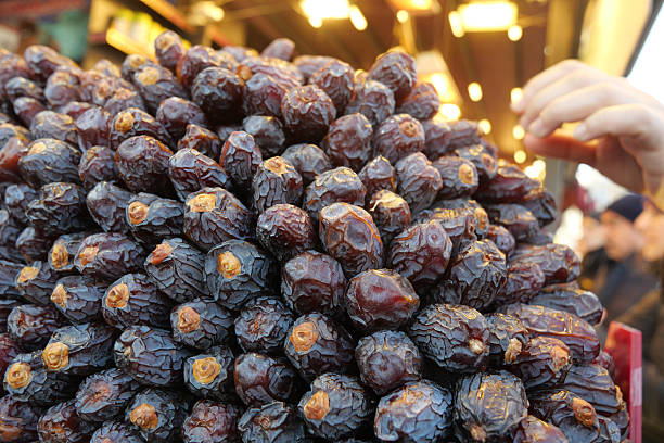 Fresh dates stacked at a market stand in the evening