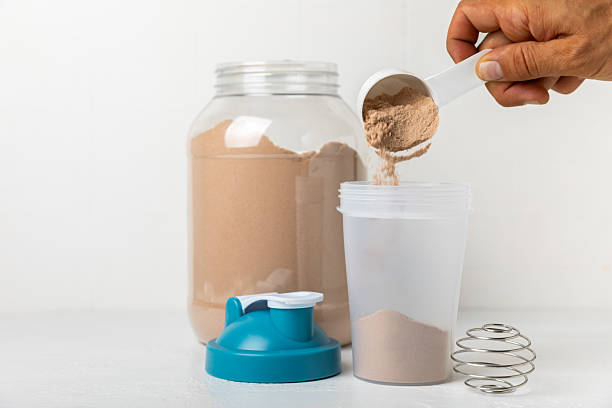 istock Protein shake with protein powder on a colored background. The powder is mixed with water or milk. A dietary supplement for a balanced diet. Whey protein. Fitness and gym diet nutrition. 2241460812