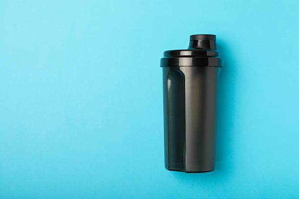 istock Protein shake with protein powder on a colored background. The powder is mixed with water or milk. A dietary supplement for a balanced diet. Whey protein. Fitness and gym diet nutrition. 2241460819