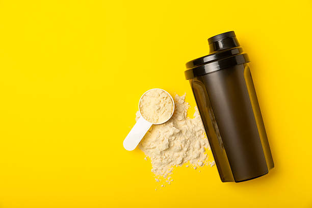 istock Protein shake with protein powder on a colored background. The powder is mixed with water or milk. A dietary supplement for a balanced diet. Whey protein. Fitness and gym diet nutrition. 2241460856