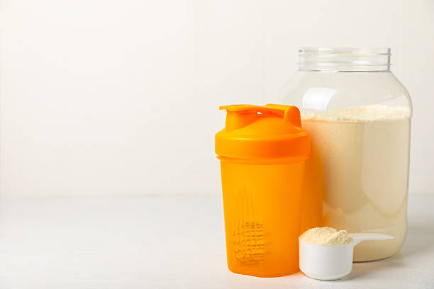 istock Protein shake with protein powder on a colored background. The powder is mixed with water or milk. A dietary supplement for a balanced diet. Whey protein. Fitness and gym diet nutrition. 2241460894