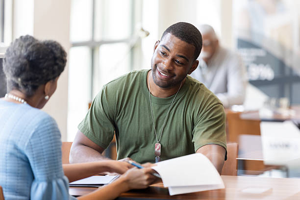 istock Veterans discuss paperwork, smiling during a professional meeting. 2241463125
