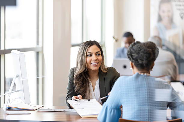 istock Two women in a professional setting, discussing documents and smiling. 2241463156