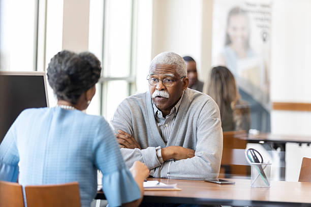 istock Experienced senior man actively discusses important matters with a professional colleague in an office setting. 2241463172
