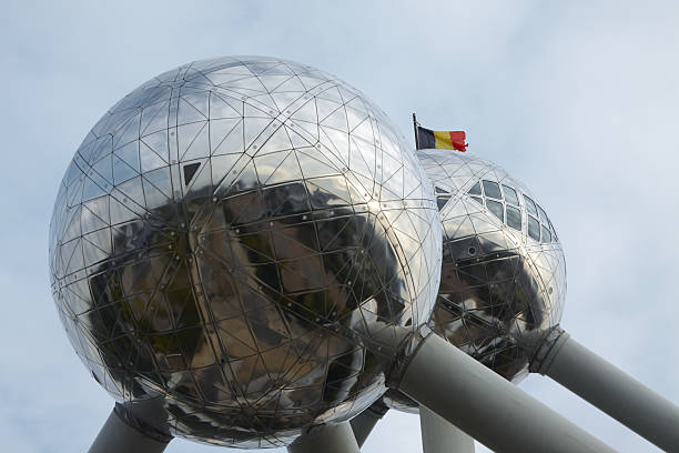 Brussels, Belgium - October 01, 2025: Atomium in Laeken Park features reflective spheres and the Belgian flag, creating a striking architectural scene
