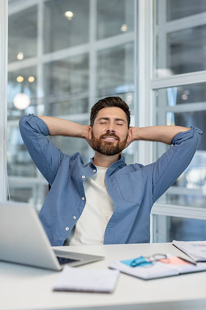 istock Happy man relaxing at desk after work success 2241470656