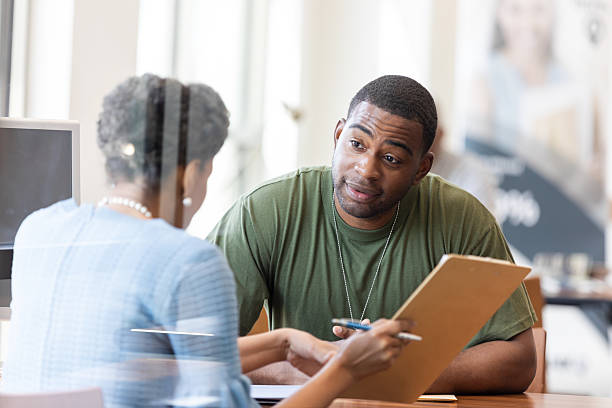 istock Man in military uniform discusses information on a clipboard with a professional. 2241471767