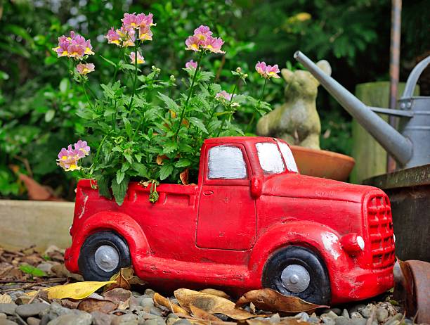 Wonderful bright red garden model truck with a flowering plant in it.