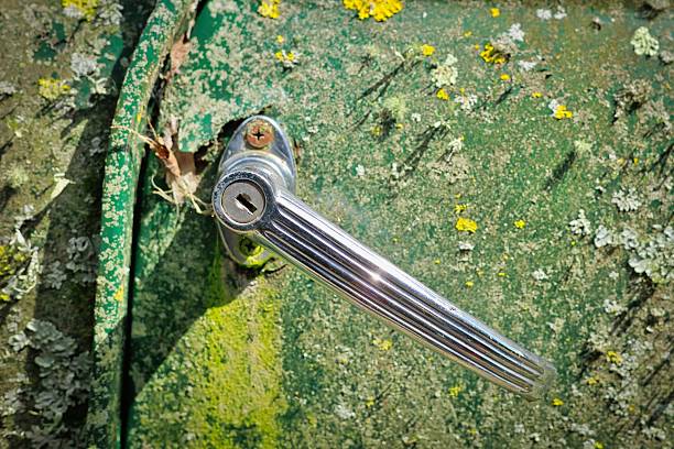 Abstract of a chrome vintage door handle on a old green door.