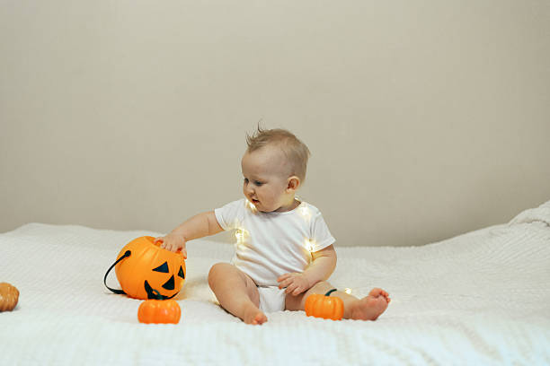istock Baby Playing with Halloween Decorations and Lights 2241477144